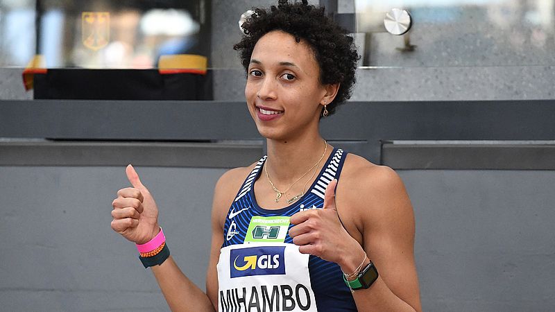 Malaika Mihambo 一边比赛，一边竖起两个大拇指。